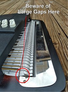 The aluminum anchor bar on 'Type B' and 'Type C' Oscar Schmidts isn't fastened down permanently.  On some harps, especially those made in the last 20 years, it can pull up out of place and start to damage the face. Click for bigger photo.
